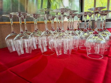 Şarabın üzerindeki bardaklar masanın üstünde ters çevrilmiş, parti için bekliyorlar. Kırmızı arka plan. Yüksek kalite fotoğraf