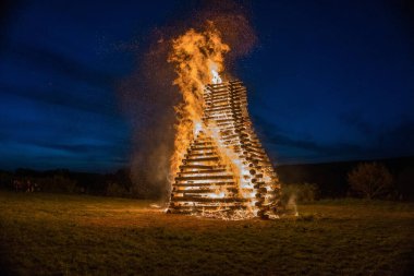 Bir cadının yanması. 30 Nisan 'da Çek Cumhuriyeti' nde tatil. Revnice. Ateş siyah arkaplanda parçacıkları kor haline getirir. Yangın arka plan kıvılcımları. Soyut koyu parıltılı ateş parçacıkları ışıkları.