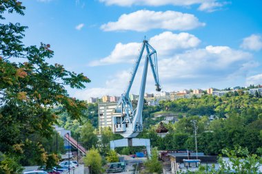 Prag - Çek - 5 Ağustos 2024: Vltava Nehri yakınlarındaki kentsel inşaat alanında mavi gökyüzünün altında faaliyet gösteren inşaat vinci. Yüksek kalite fotoğraf