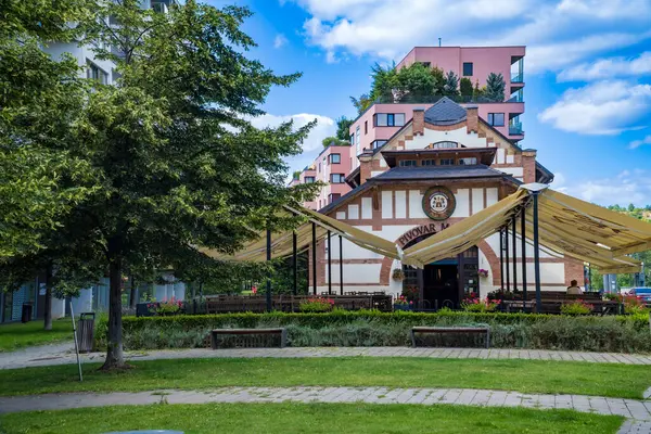 Prag - Çek - 5 Ağustos 2024: eski bir ahşap ev yeni bir yüksek binanın arka planında duruyor. Yüksek kalite fotoğraf