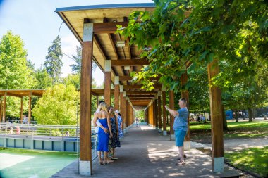 Podebradi- Çek- 27 Temmuz 2024: İnsanlar ağaçların gölgesindeki sıcaktan ve su damlalarından, Central Park 'taki çeşmeden kaçıyorlar. Yüksek kalite fotoğraf