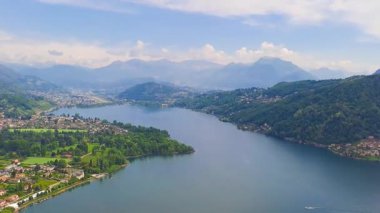Caslano- Switzerland - 2 Mayıs 2025: İsviçre ve İtalya sınırındaki Lugano Gölü 'nün üst manzarası. Yüksek kaliteli FullHD görüntüler