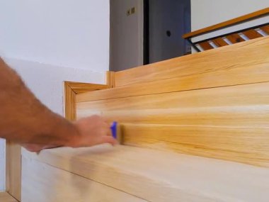 Bir marangoz ahşap bir merdiveni vernikle kaplar. Bir işçi ahşabı boyayla boyar. Yüksek kaliteli HD görüntüler