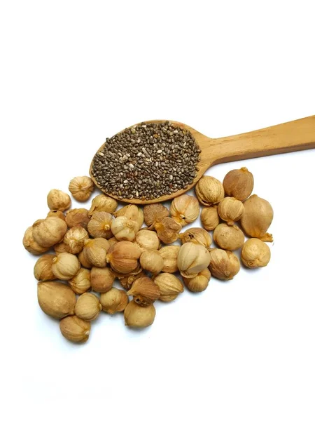 Kakule ve chia tohumları beyaz kaşıkta izole edilmiş.