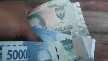 Endonezya rupia paralarını tek tek sayarak.