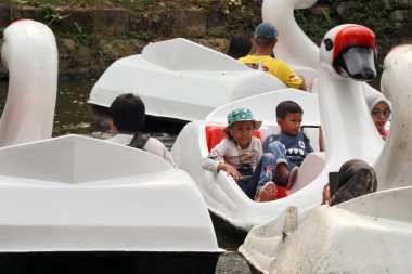 Jakarta, Endonezya - 13 Ağustos 2023: çocuklar göl turistik bölgesinde ördek teknesiyle gezintiye çıkıyorlar.