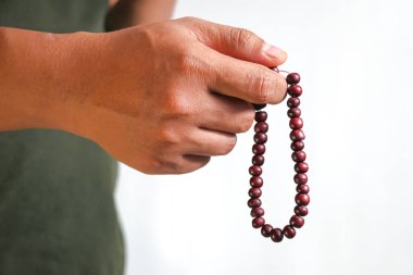 Beyaz bir arkaplanda el ele dua boncukları.