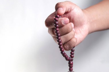 Beyaz bir arkaplanda el ele dua boncukları.