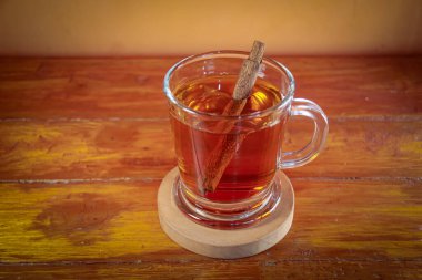 Bardak betel ve tarçınlı bitki çayıyla dolu. 