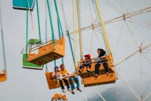 stock image Bandung, Indonesia - July 6, 2024: mother and child while riding the flying tower ride at a tourist attraction, Bandung.