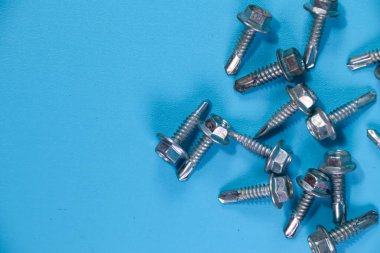 Mavi arkaplanda izole edilmiş çatı metal levhası için sondaj vidaları,