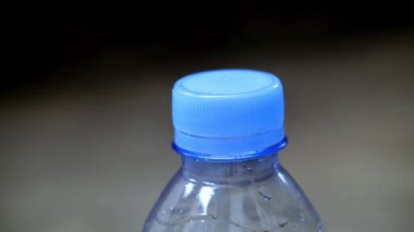 Plastik su şişesinin kapağını aç. Kapat.