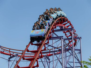 Jakarta, Endonezya - 8 Eylül 2024: Halilintar yolculuğu veya hız treni Dufan lunaparkında, mavi gökyüzü arka planı.