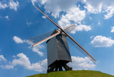 Bulutlu mavi gökyüzüne karşı eski bir yel değirmeni