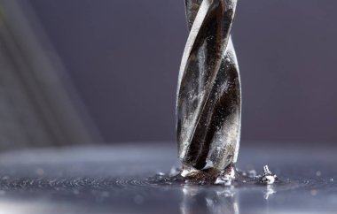 Kayganlaştırıcı yağ ile metal matkap ucu endüstriyel sondaj makinesinde çelik bölmede delikler açar. Metal iş endüstrisi