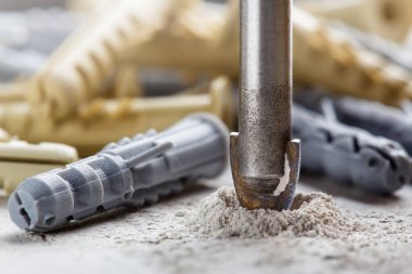 Metal matkap ucu, endüstriyel sondaj makinesinde talaşlarla beton duvarda delikler açar. Metal iş endüstrisi