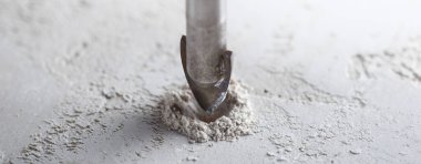 Metal matkap ucu, endüstriyel sondaj makinesinde talaşlarla beton duvarda delikler açar. Metal iş endüstrisi