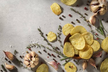 Cips, patates cipsi, sarımsaklı, biberiyeli, gri taşlı arka planda kasede. Abur cubur mu fast food mu?.