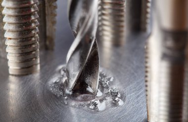 Kayganlaştırıcı yağ ile metal matkap ucu endüstriyel sondaj makinesinde çelik bölmede delikler açar. Metal iş endüstrisi