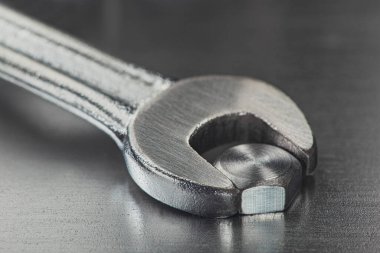 İngiliz anahtarı çelik koğuşta cıvatayı sıkıyor. Anahtar, cıvata, vida ve fındık.