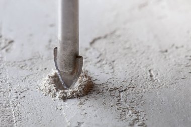 Metal matkap ucu, endüstriyel sondaj makinesinde talaşlarla beton duvarda delikler açar. Metal iş endüstrisi