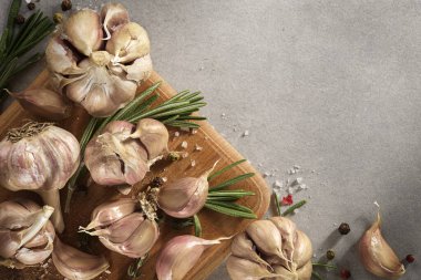 Baharatlar, bitkiler, gri arka planda zeytinyağı. Sarımsak, biberiye, maydanoz, üst manzara.