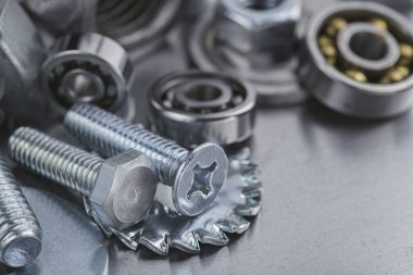 Farklı somunlar, civatalar, vidalar, yıkama ve matkap uçları çelik plaka arka planında ip dokusu ve değirmen kesiciler. Çilingir anlaşması.