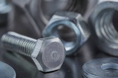 Farklı somunlar, civatalar, vidalar, yıkama ve matkap uçları çelik plaka arka planında ip dokusu ve değirmen kesiciler. Çilingir anlaşması.