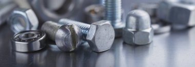 Farklı somunlar, civatalar, vidalar, yıkama ve matkap uçları çelik plaka arka planında ip dokusu ve değirmen kesiciler. Çilingir anlaşması.