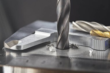 Matkap ucu, çelik bölmede, cetvel ve kalibre ile endüstriyel sondaj makinesinde delikler açar. Metal iş endüstrisi. çoklu kesme aracı ve son değirmen.