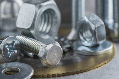 Farklı somunlar, civatalar, vidalar, yıkama ve matkap uçları çelik plaka arka planında ip dokusu ve değirmen kesiciler. Çilingir anlaşması.