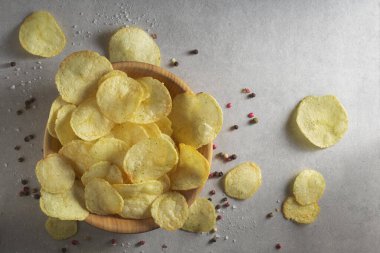 Tahta bir bağırsağın içinde baharatlı patates cipsi yığını. Fast food geçmişi kavramı. Metin için boş yer, üst görünüm.