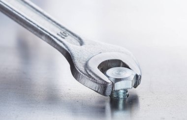 İngiliz anahtarı çelik koğuşta cıvatayı sıkıyor. Anahtar, cıvata, vida ve fındık.