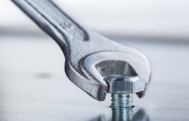 İngiliz anahtarı çelik koğuşta cıvatayı sıkıyor. Anahtar, cıvata, vida ve fındık.