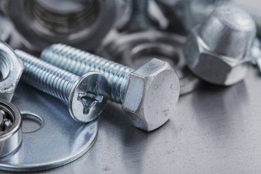 Farklı somunlar, civatalar, vidalar, yıkama ve matkap uçları çelik plaka arka planında ip dokusu ve değirmen kesiciler. Çilingir anlaşması.