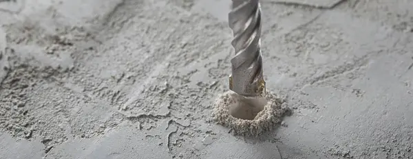 drill bit make holes in concrete wall with industrial drill. Building work industry.