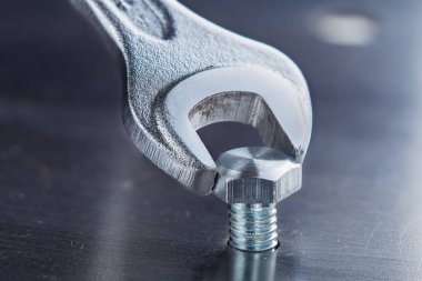 İngiliz anahtarı çelik koğuşta cıvatayı sıkıyor. Anahtar, cıvata, vida ve fındık.