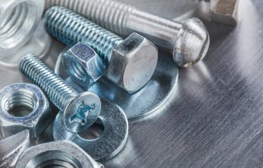 Farklı somunlar, civatalar, vidalar, yıkama ve matkap uçları çelik plaka arka planında ip dokusu ve değirmen kesiciler. Çilingir anlaşması.