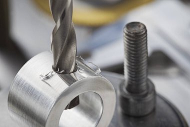 Metal matkap ucu endüstriyel sondaj makinesinde alüminyum boruda delikler açar. Metal iş endüstrisi.