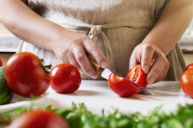 Şef restoranda domatesleri bıçakla dilimliyor. Mutfakta kesim ve hazırlama işlemi.