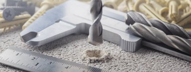 Metal matkap ucu, beton duvarda plastik kaplama ve duvar tıkaçlarıyla delikler açar. Çalışma endüstrisi inşa ediliyor.