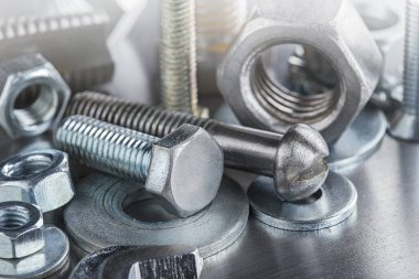 Farklı somunlar, civatalar, vidalar, yıkama ve matkap uçları çelik plaka arka planında ip dokusu ve değirmen kesiciler. Çilingir anlaşması.