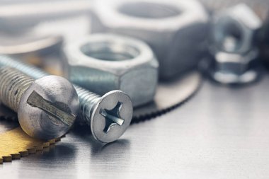 Farklı somunlar, civatalar, vidalar, yıkama ve matkap uçları çelik plaka arka planında ip dokusu ve değirmen kesiciler. Çilingir anlaşması.