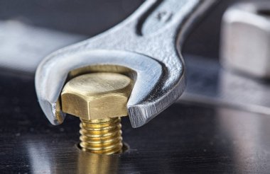 İngiliz anahtarı çelik koğuşta cıvatayı sıkıyor. Anahtar, cıvata, vida ve fındık.