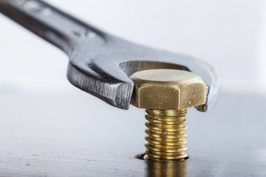 İngiliz anahtarı çelik koğuşta cıvatayı sıkıyor. Anahtar, cıvata, vida ve fındık.