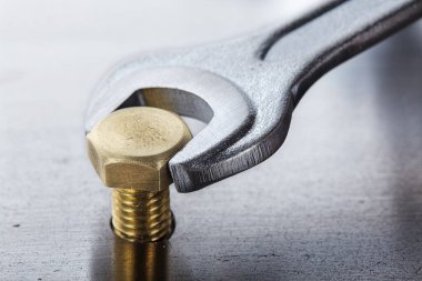 İngiliz anahtarı çelik koğuşta cıvatayı sıkıyor. Anahtar, cıvata, vida ve fındık.