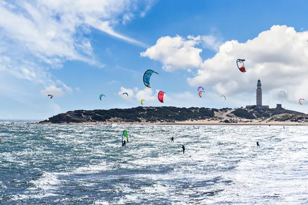 Los Canos de Meca, Barbate, Cdiz; 19 Ağustos 2022: Trafalgar Deniz Feneri sahilinin önünde uçurtma sörfü yapan atletler.