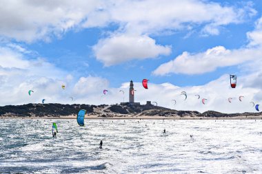 Los Caos de Meca, Barbate, Cdiz; 19 Ağustos 2022: Trafalgar Deniz Feneri sahilinin önünde uçurtma sörfü yapan atletler