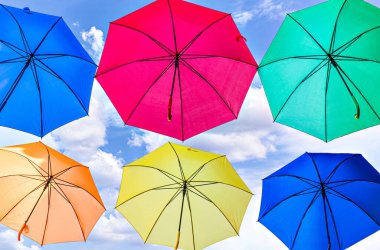 Bir şehrin caddesini süsleyen renkli şemsiyelerin arka planı