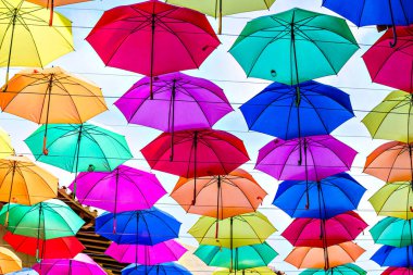 Bir şehrin caddesini süsleyen renkli şemsiyelerin arka planı